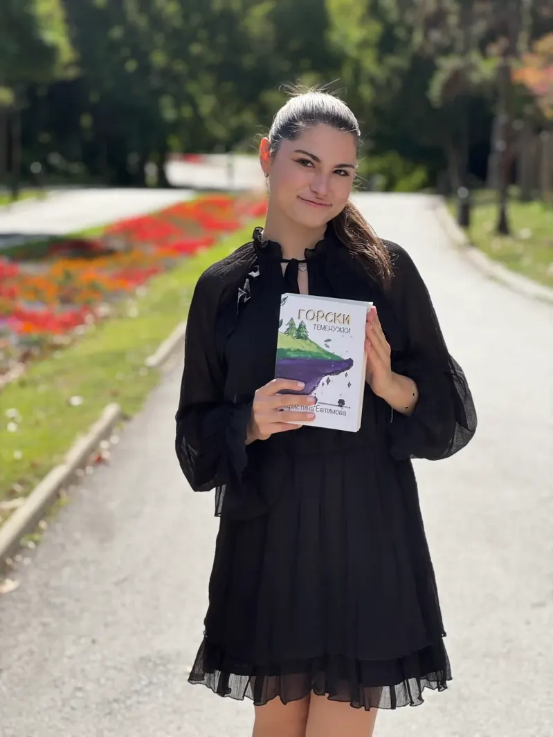 Кристина Евтимова с книгата „Горски теменужки“ в парка